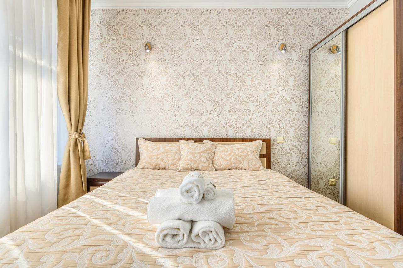 Cameră dublă deluxe — pat și perdele crem cu lumină naturală
