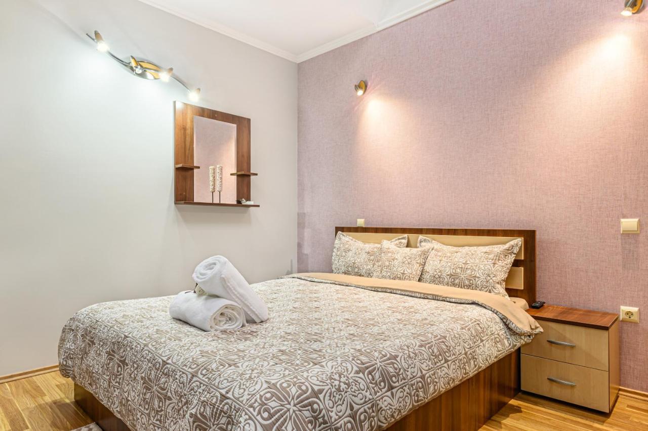 Cameră dublă deluxe — pat cu accent violet și veioze